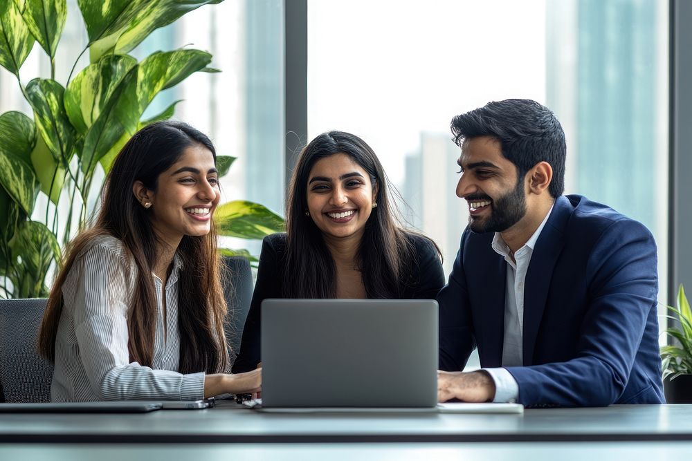 Three Indian business people working laptop happy professional.