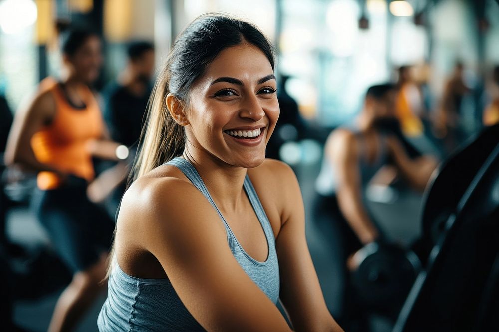 Woman doing a workout in a gym equipment smiling person.