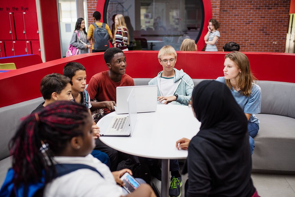 Diverse group of students studying together. Students with laptops, students discussing, students collaborating. Group of…