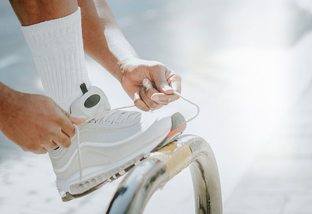 Athlete tying white running shoes