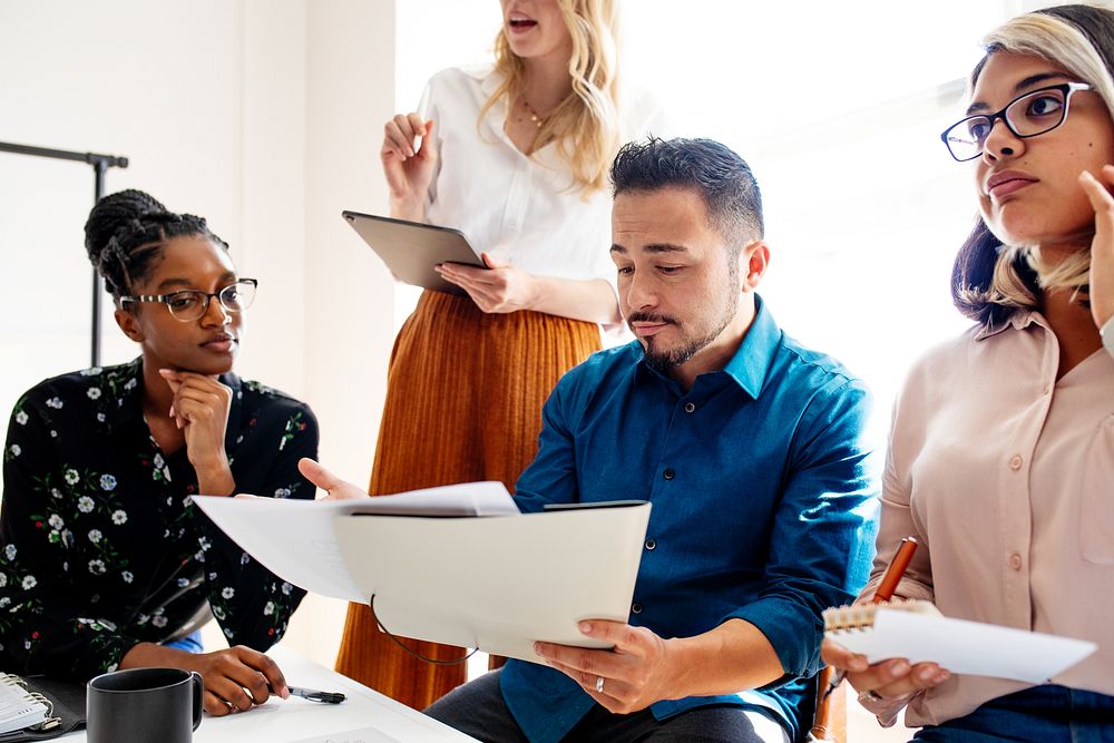 Diverse team in a meeting. A diverse team in a business meeting. The team discusses and brainstorm. The diverse business…