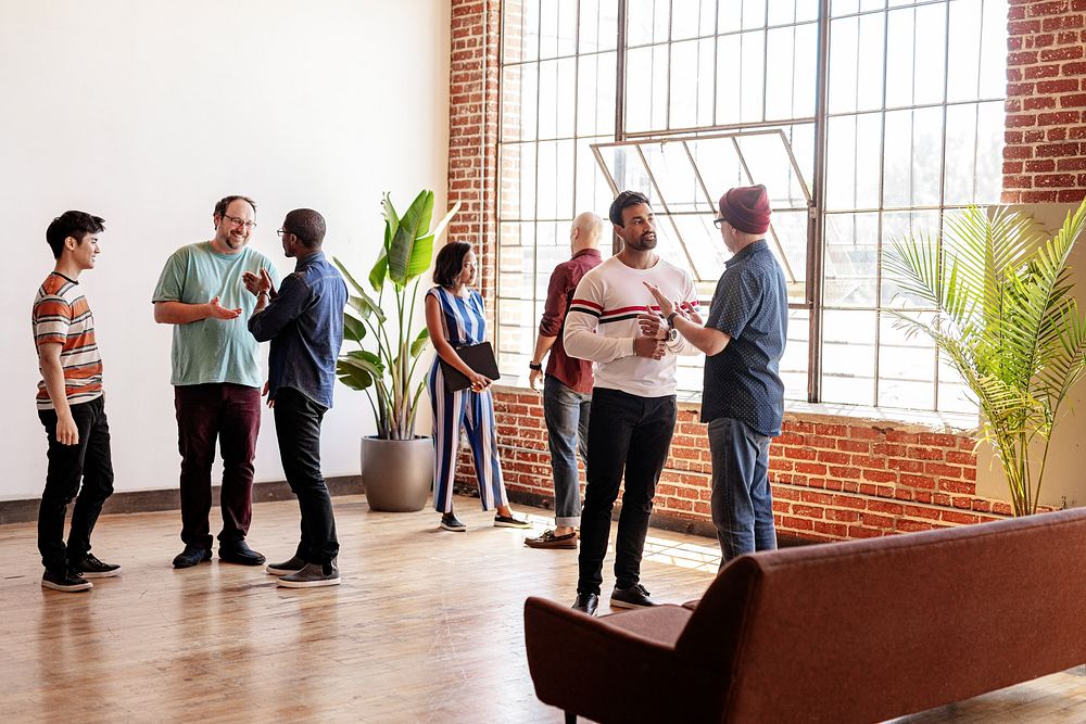 Diverse group of people in casual modern office, discuss ideas. Diverse men and women team in office, casual social meeting.…