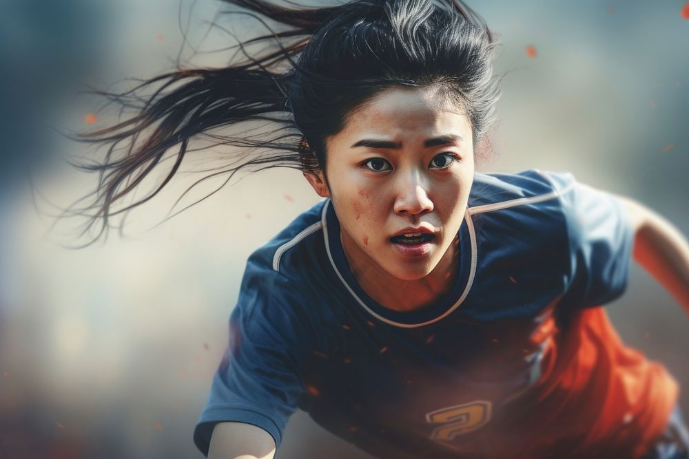 Asian woman playing soccer motion determination competition.