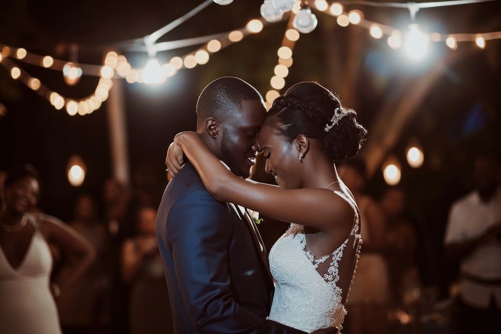 Black couple dancing at their wedding lighting adult bride.