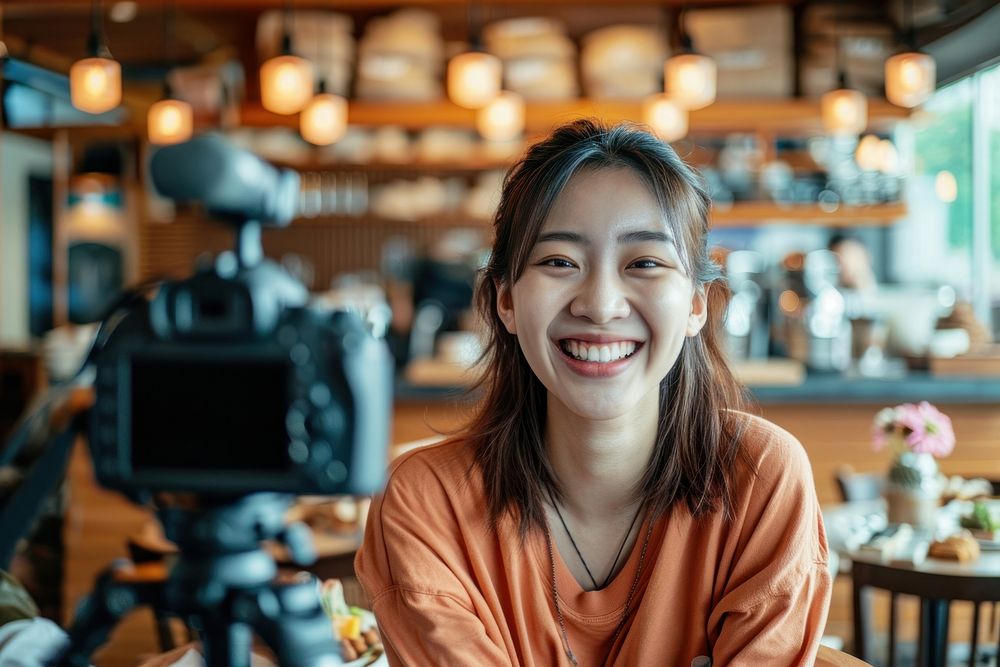 Happy asian girl recording desert review at cafe portrait selfie smile.