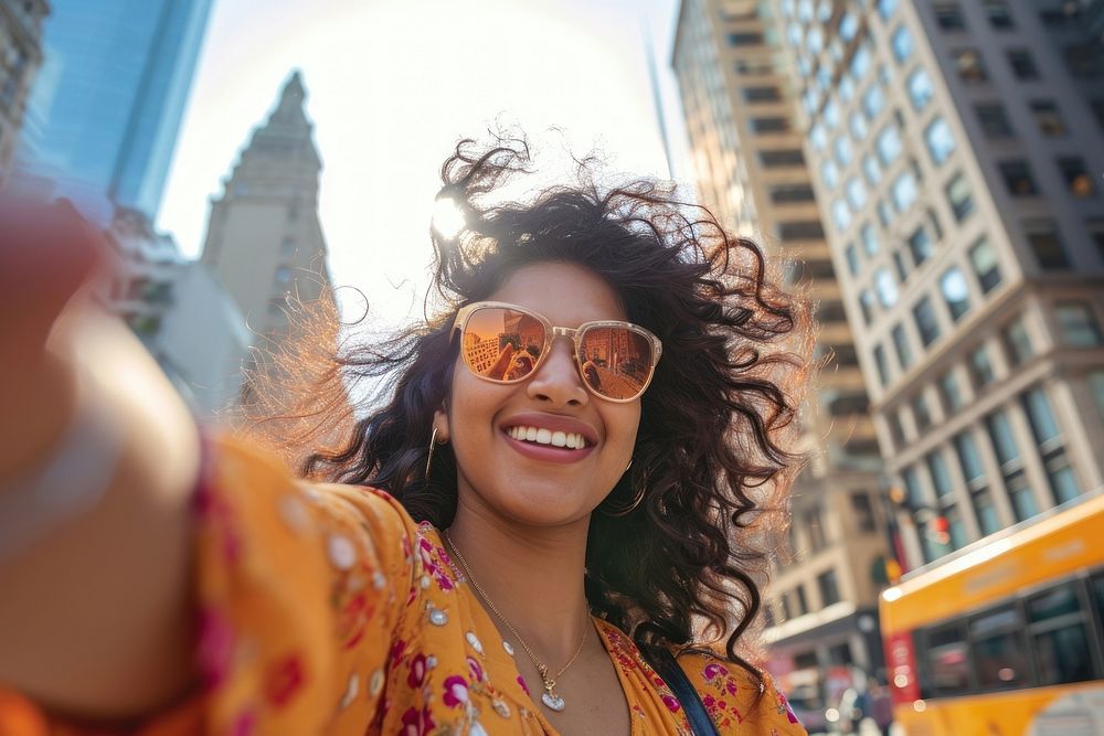Indian american woman city sunglasses laughing.