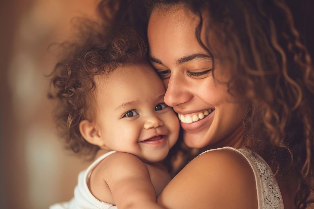 Mom holding a girl baby laughing portrait adult.
