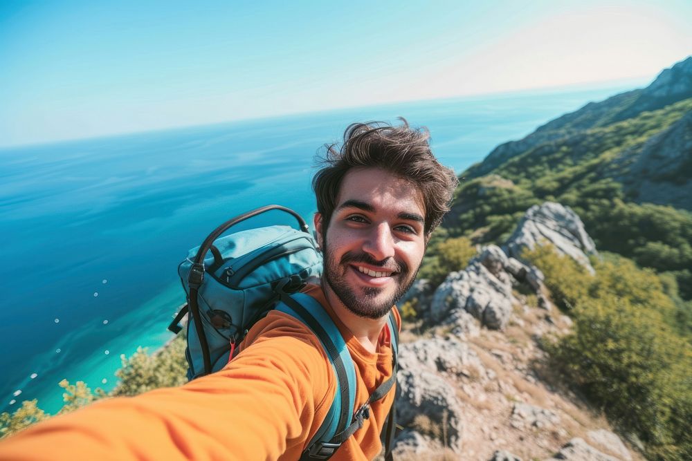 Young hiker Middle eastern man taking selfie mountain climbing portrait.