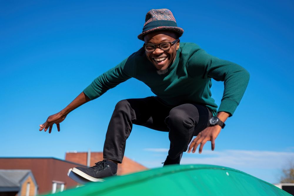 Black man in a green hat skateboarding jumping smile adult.
