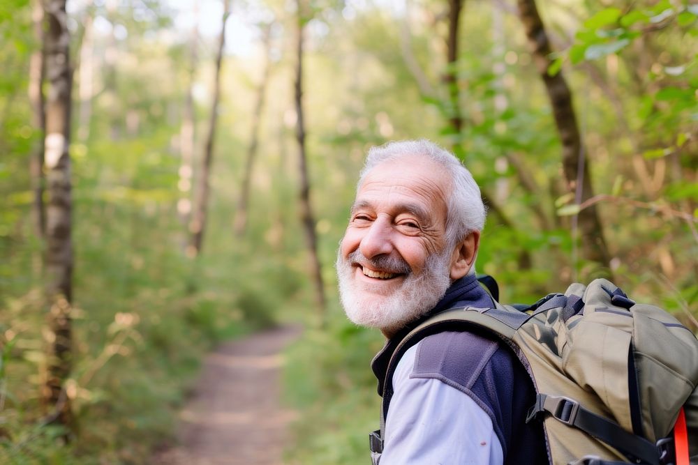 Senior Middle eastern man hiking outdoors forest backpacking recreation.