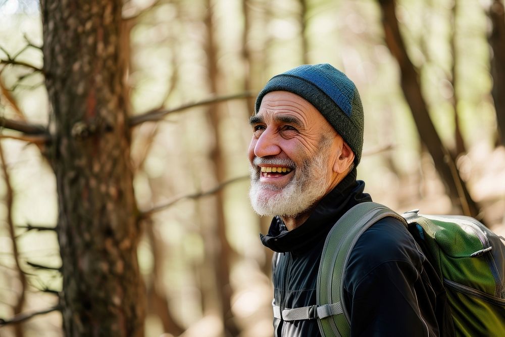 Senior Middle eastern man hiking outdoors backpacking adventure forest.