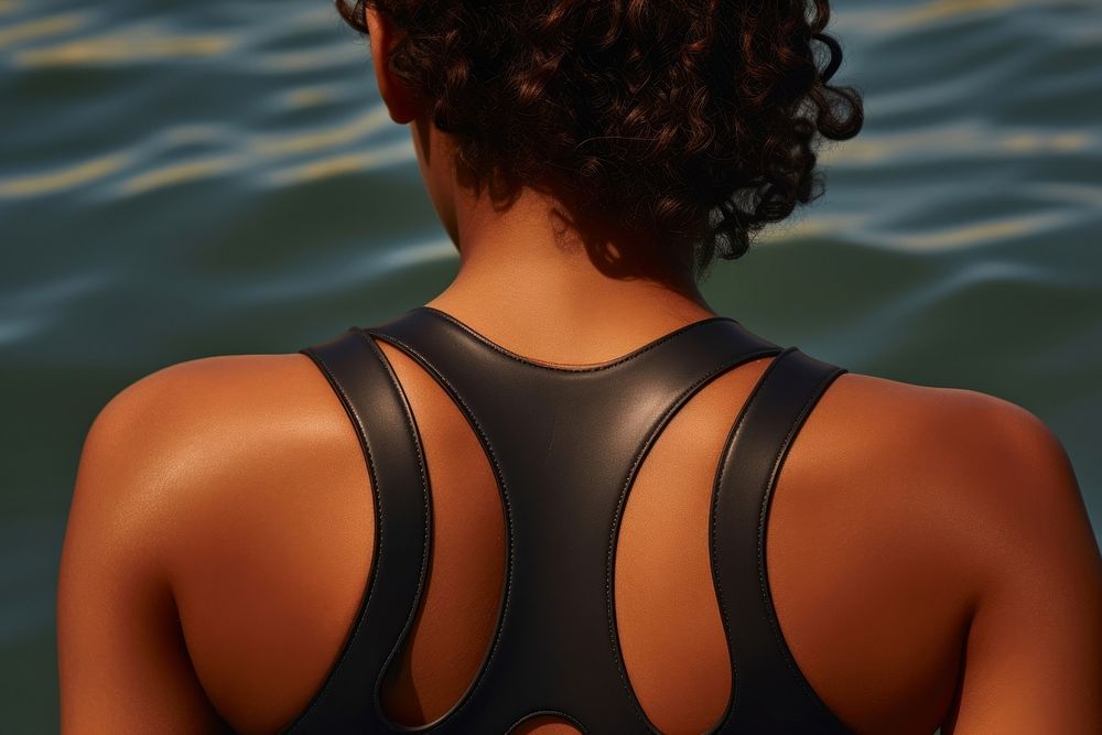 The back of a black person wearing a swimming costume adult exercising hairstyle.