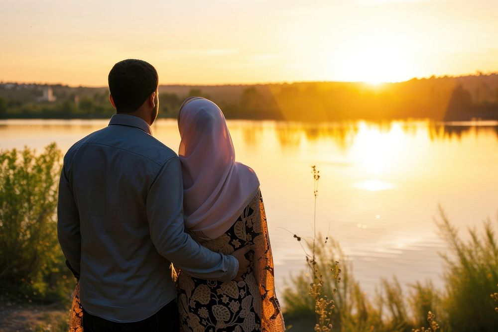 Young wealthy middle eastern couple standing outdoors sunset.