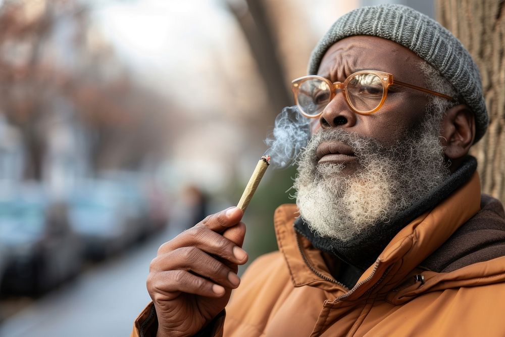 Black man holding cannabis joint smoking adult smoke.