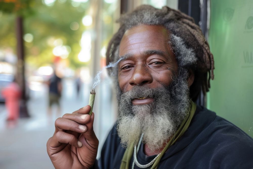 Black man holding cannabis joint smoking adult smile.