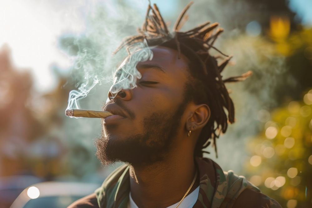 Black man smoking cannabis joint adult smoke contemplation.
