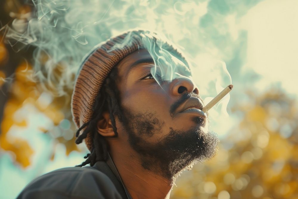 Black man smoking cannabis joint smoke adult contemplation.