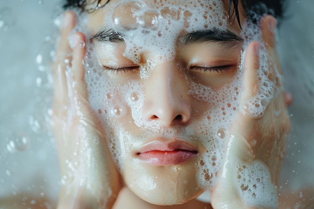 Korean man washing face headshot.