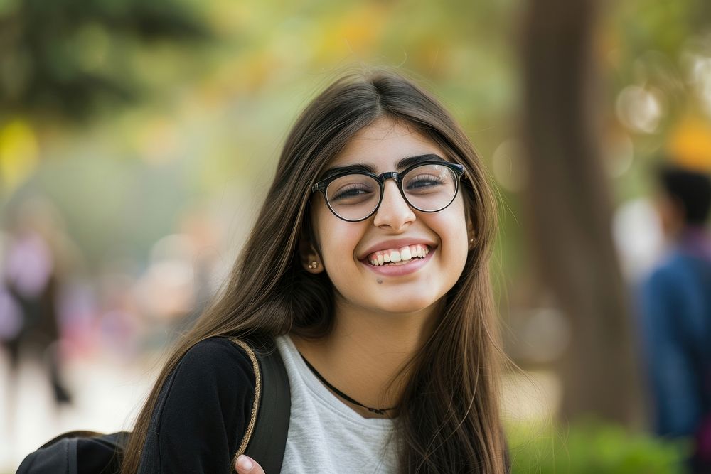 Middle-eastern college girl glasses portrait outdoors.