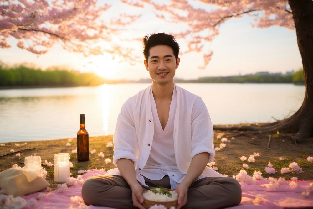 East Asian Sunset Picnic Under Cherry Blossoms sitting picnic sunset. AI generated Image by rawpixel.