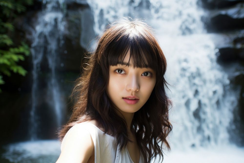 East Asian Cooling Off in a Waterfall Oasis waterfall portrait outdoors. AI generated Image by rawpixel.