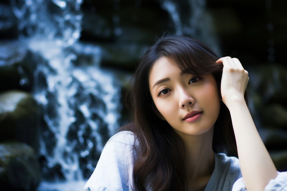 East Asian Cooling Off in a Waterfall Oasis waterfall portrait photo. AI generated Image by rawpixel.