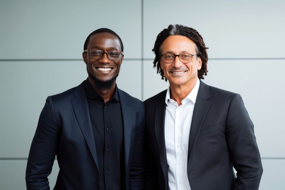 African businessmen shaking hands standing smiling glasses.