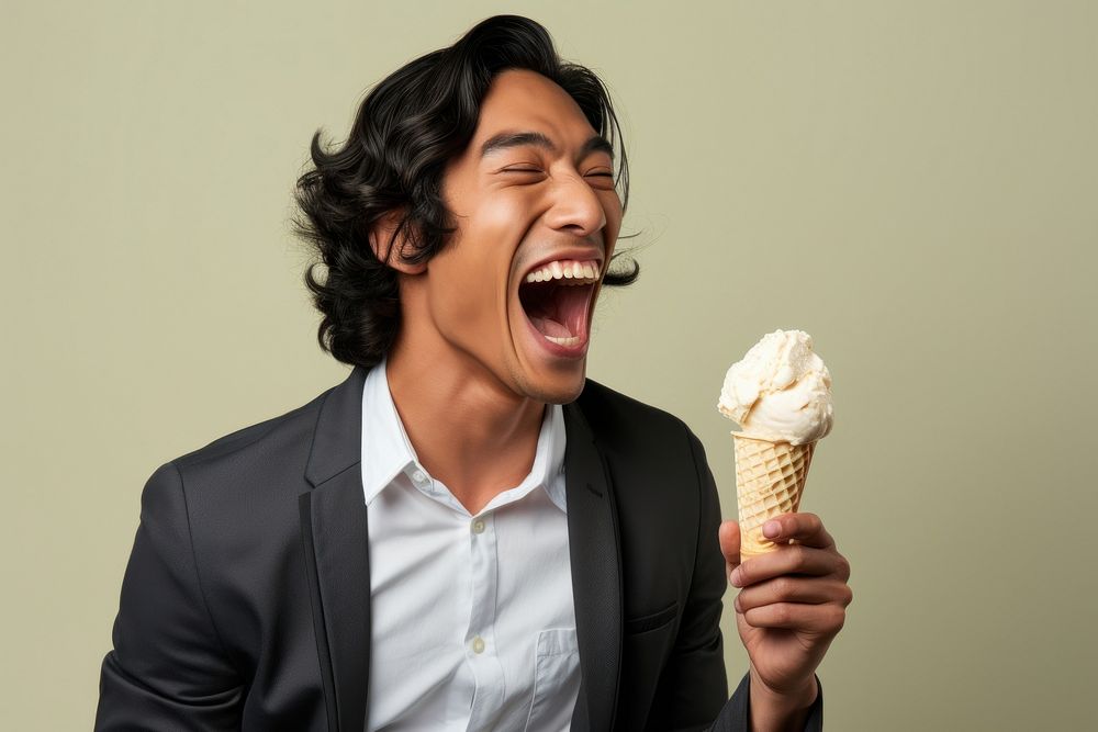Vietnamese man laughing eating cream.