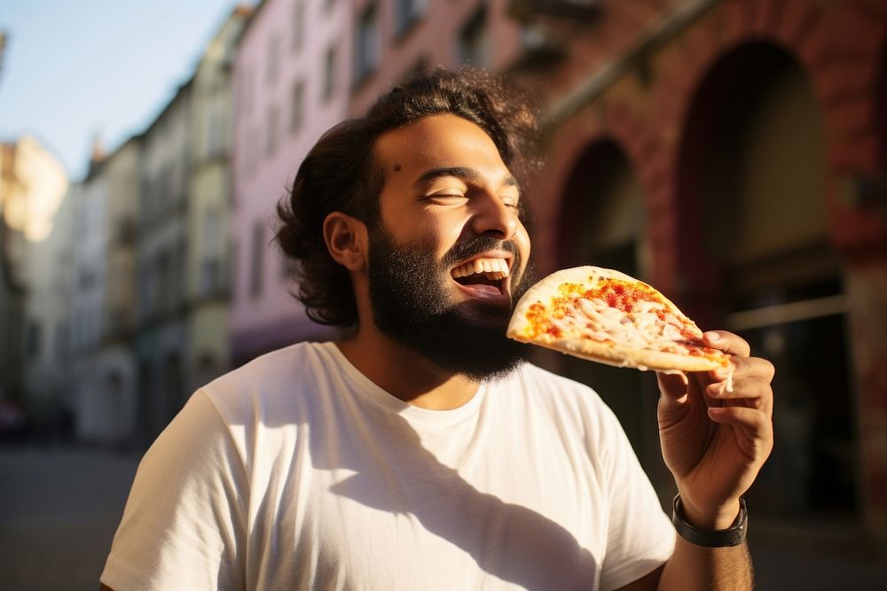 Bangladeshi man eating pizza biting.