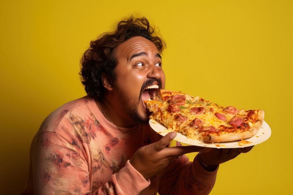Bangladeshi man eating pizza biting.