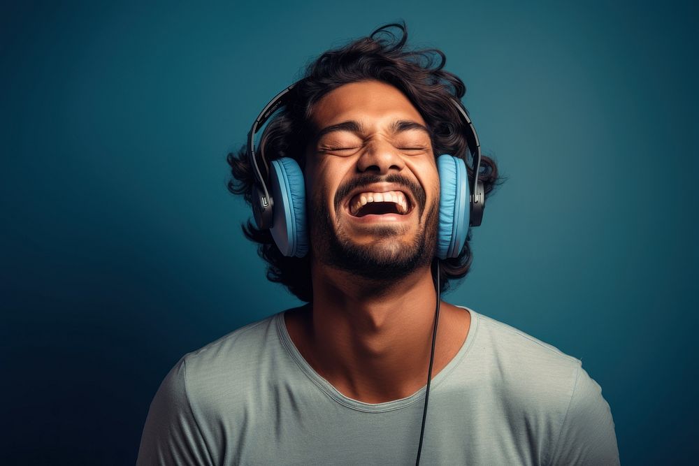 Indian man headphones shouting laughing.