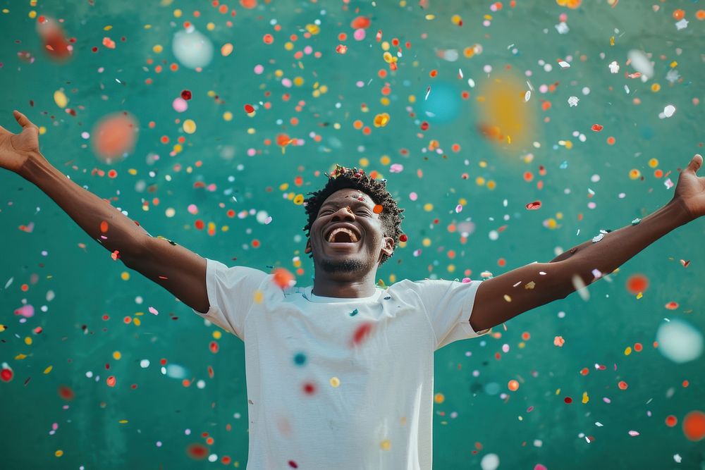 Cheerful black man with confetti enjoying cheerful celebration celebrating.