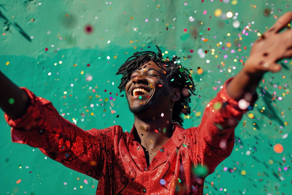 Cheerful black man with confetti enjoying cheerful performance celebration.