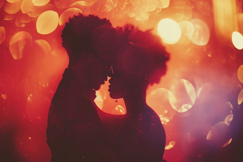 Black people descent couple dancing wedding celebrate kissing light red.