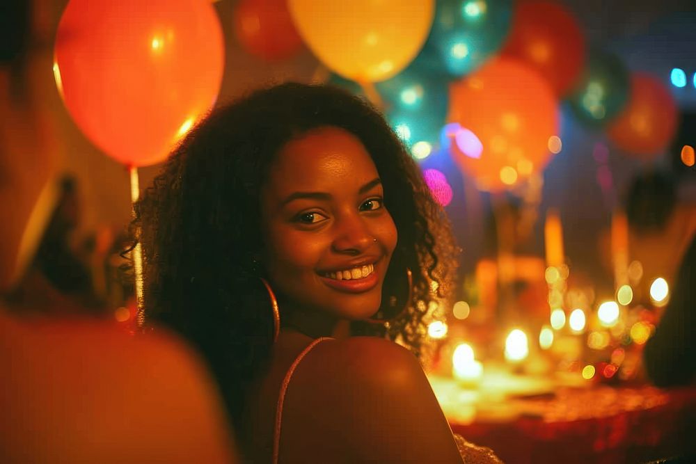 Black woman at birthday party balloon looking smile.