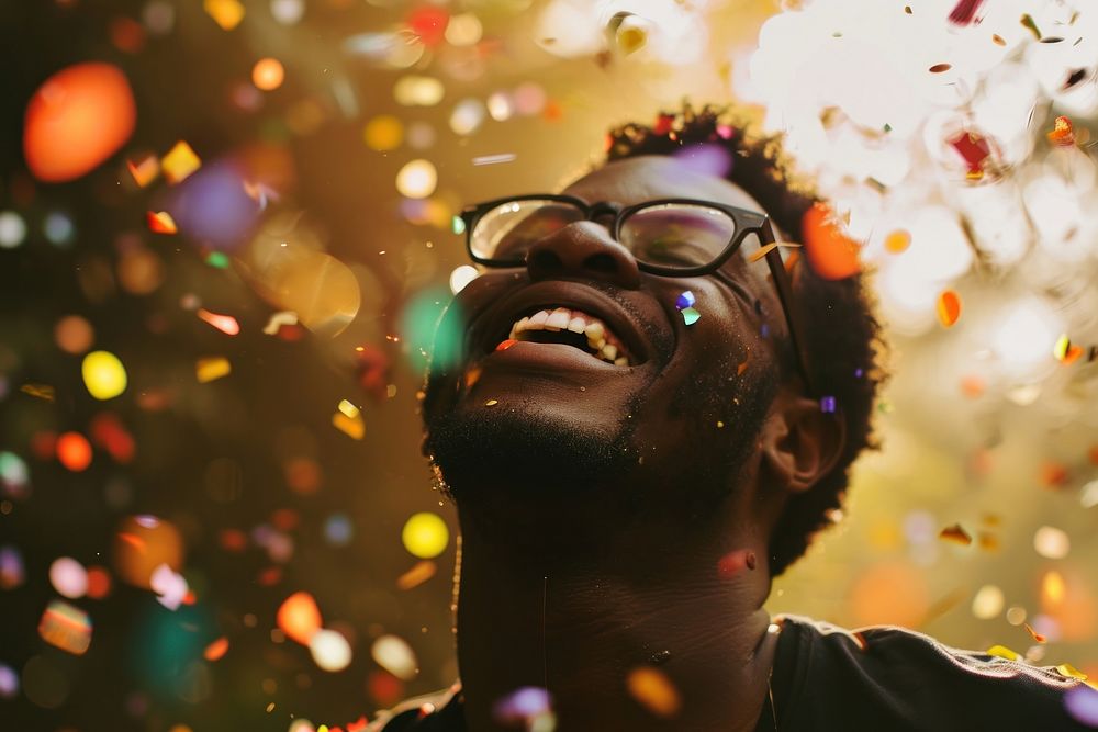 Cheerful black man with confetti enjoying photography cheerful laughing.