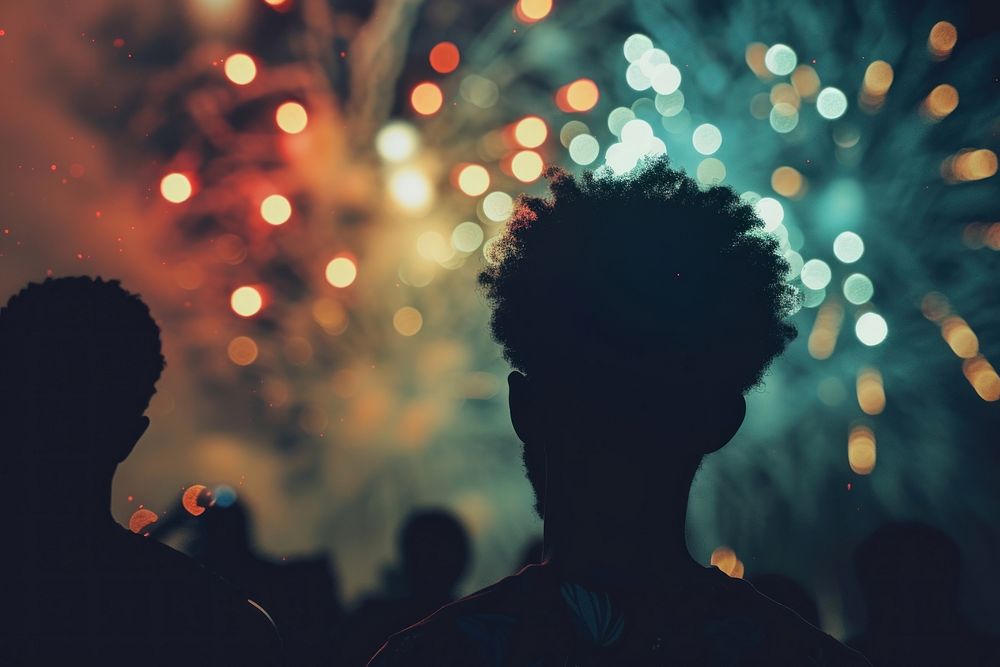 Fireworks with silhouettes of black people outdoors light night.