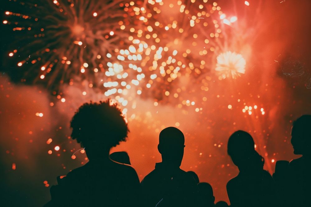Fireworks with silhouettes of black people adult togetherness illuminated.