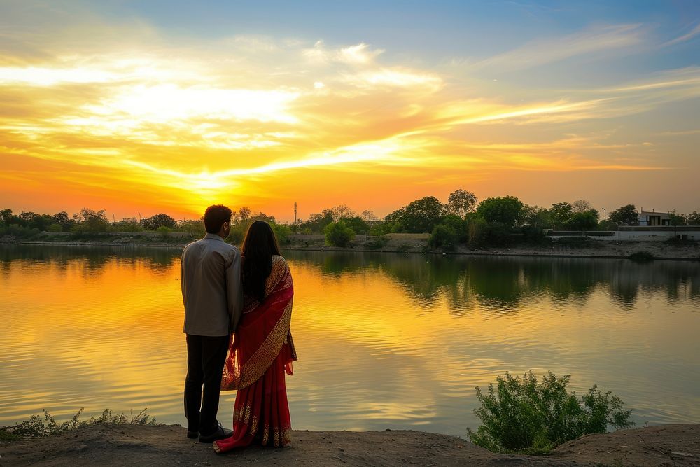 Young wealthy Indian couple lake standing outdoors.