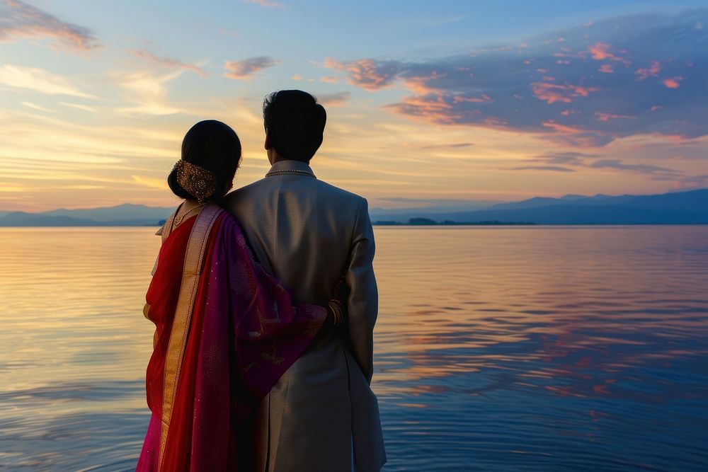 Young wealthy Indian couple standing outdoors horizon.