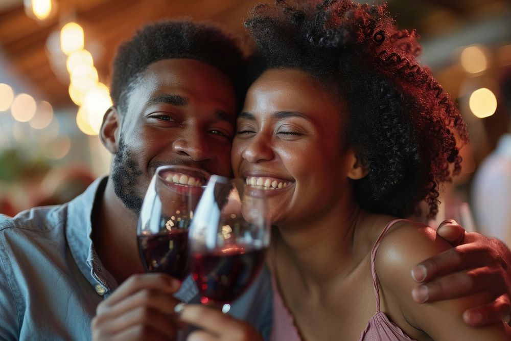 Happy black man couple celebrating embracing drinking laughing.