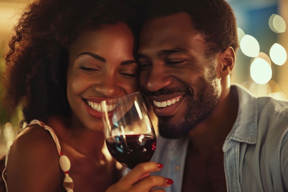 Happy black man couple celebrating embracing laughing drinking.