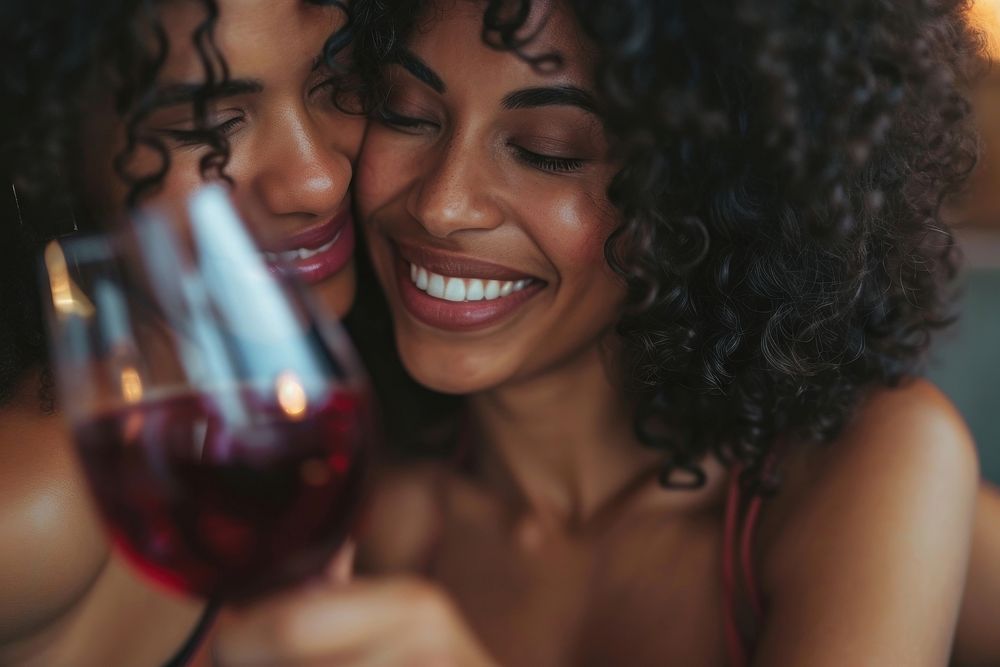 Happy black woman couple celebrating drinking laughing portrait.