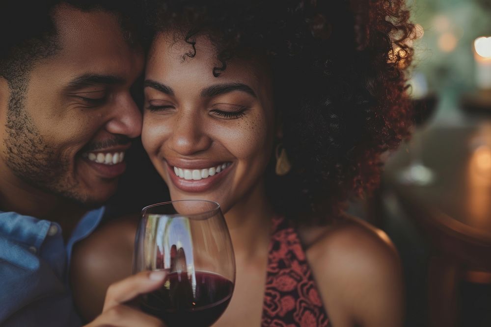Happy black woman couple celebrating embracing laughing drinking.