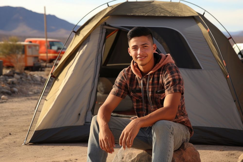 Young Mexican man outdoors camping tent.