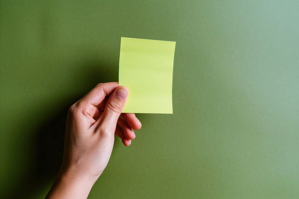 Hand holding blank green sticky note paper green background activity. AI generated Image by rawpixel.
