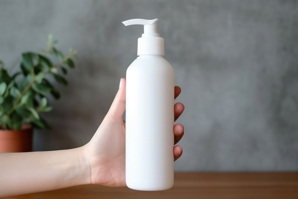 Hand gel pump bottle  holding milk container.