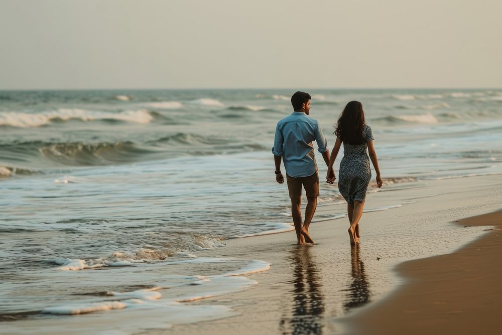 Indian young couple vacation walking beach.