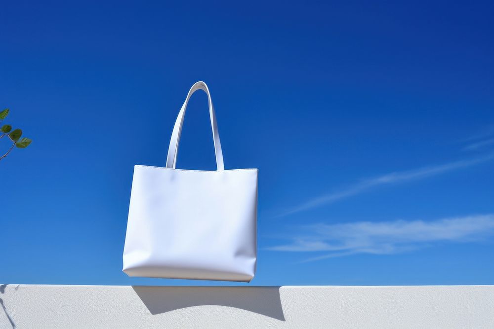 Close up white tote bag handbag blue sky.