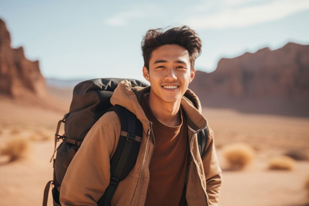 Young east asian man desert travel smile.